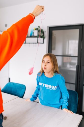 een kind blaast met een veer om te oefenen met de ademhaling obat
